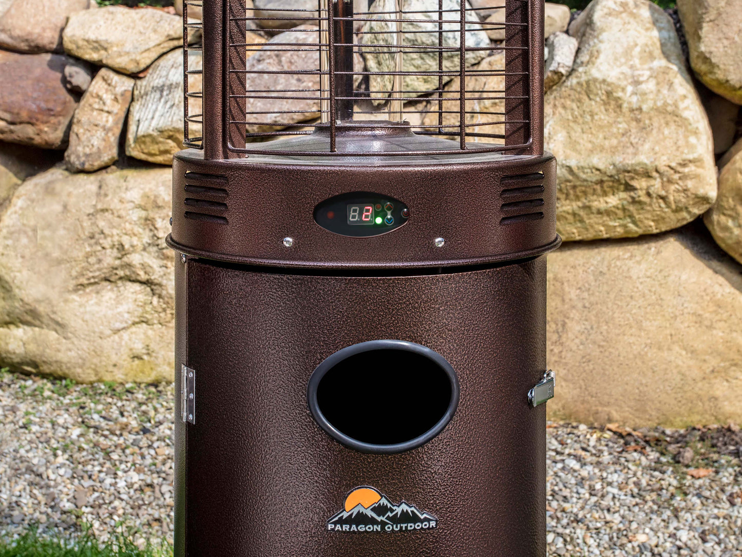 Close up of the Illume Patio Heater with digital control panel in Hammered Bronze in backyard with rocks.